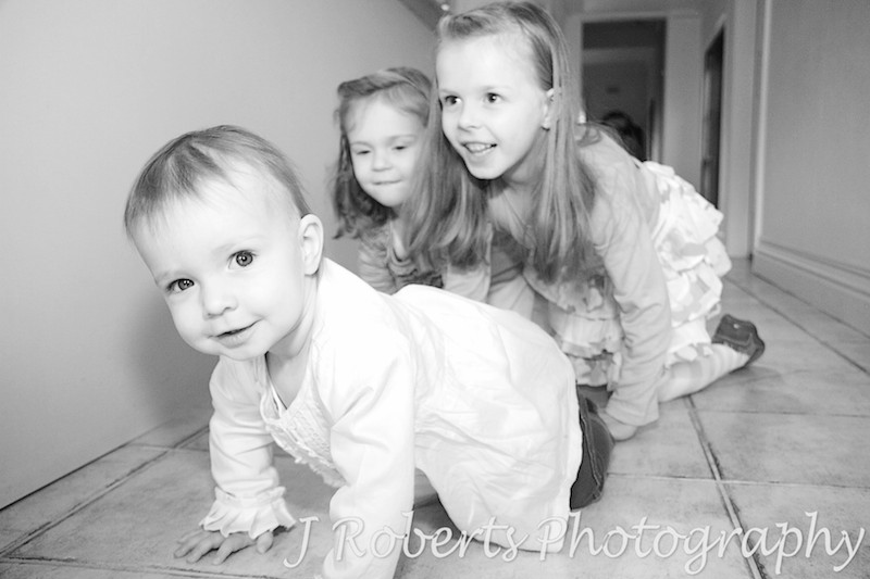 crawling race between 3 sisters - family portrait photography sydney